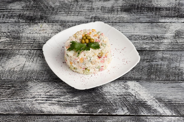 Salad olivier salad on a wooden white background