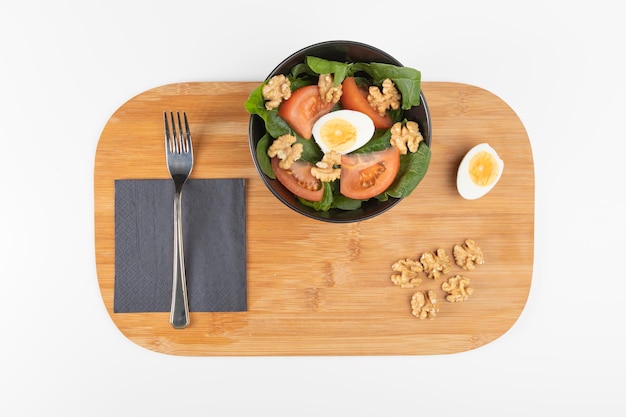 Salad plate with lettuce, tomato, egg and nuts.