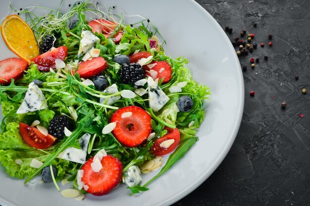 Salad Salad of arugula blue cheese strawberries and blueberries Top view