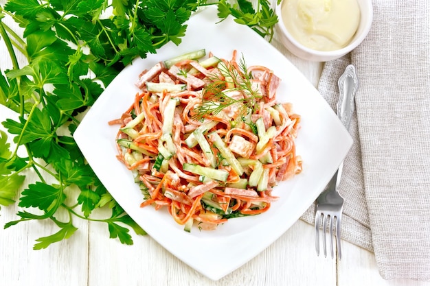 Salad of sausage and spicy carrots with mayonnaise on table top