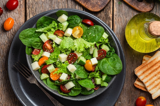 Salad of spinach cherry tomatoes and cheese in a plate