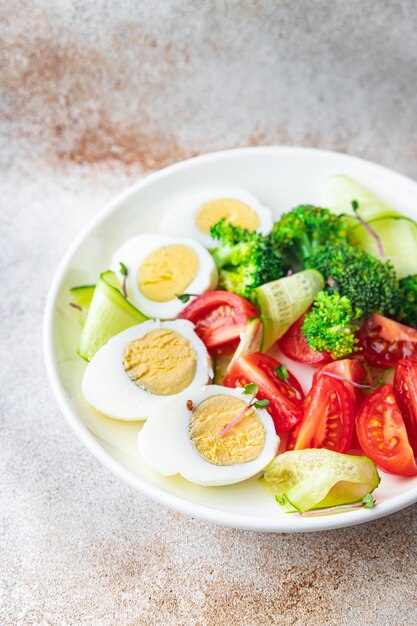 Salad vegetables and egg broccoli tomato cucumber meal snack on the table