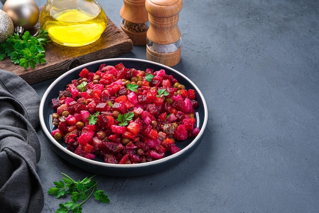 Salad vinaigrette with beetroot vegetables peas and sauerkraut on a dark background