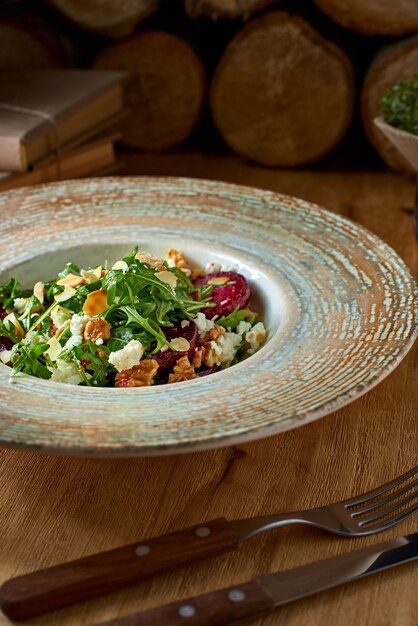 Salad with beetroot, feta cheese, arugula and spicy dressing on a rustic background. Healthly food.