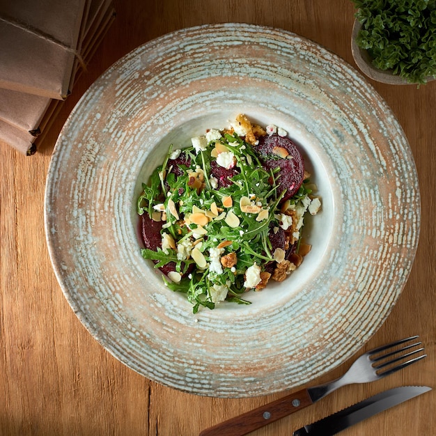 Salad with beetroot feta cheese arugula and spicy dressing on a rustic background Healthly food