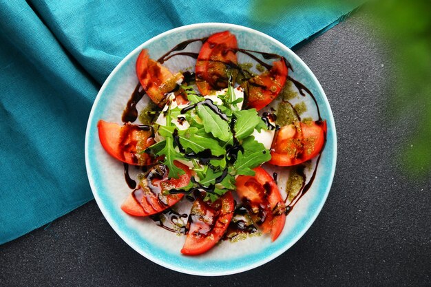 Salad with burrata basil and tomatoes top view.