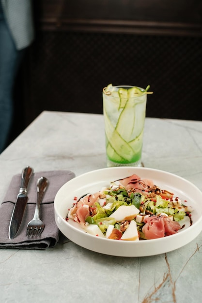 Salad with cheese ham and fruit with cold cocktail Serving food in a restaurant