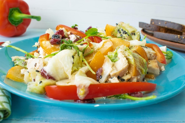 Salad with chicken and cheese with greens persimmon bell pepper The concept of diet food