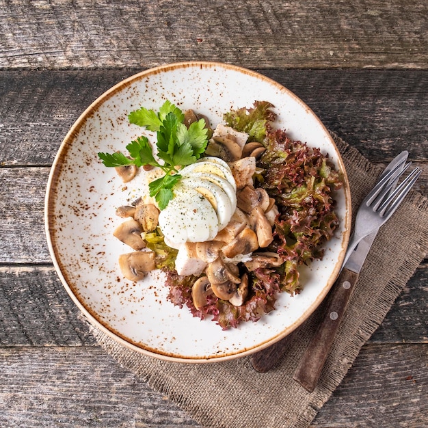 Salad with chicken mushrooms eggs and marinated cucumbers Top view