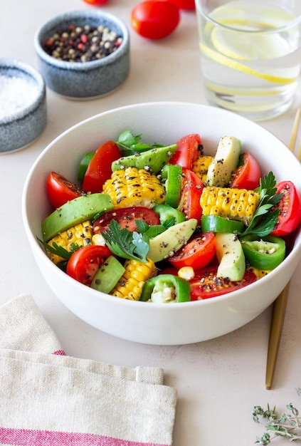 Salad with corn avocado tomatoes peppers and parsley Healthy eating Vegetarian food