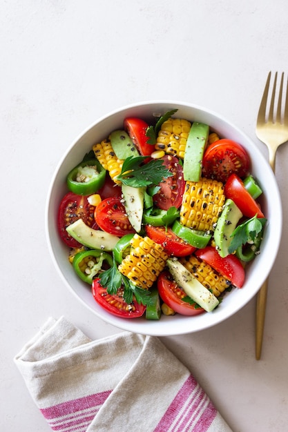 Salad with corn avocado tomatoes peppers and parsley Healthy eating Vegetarian food