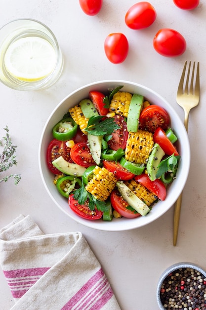 Salad with corn avocado tomatoes peppers and parsley Healthy eating Vegetarian food