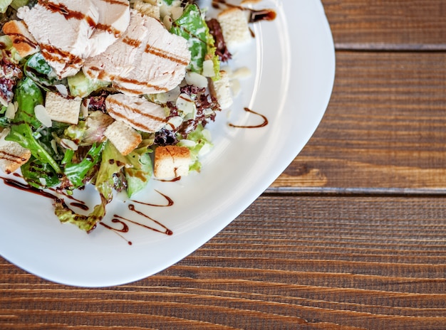 Salad with cucumber and chicken and lettuce on a wooden 