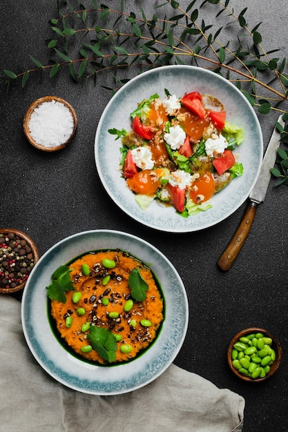 Salad with fresh vegetables and stracciatella and salad with fresh green pea or green beans salad top view in concrete table with copy space.