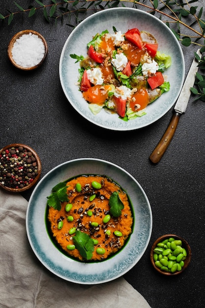 Salad with fresh vegetables and stracciatella and salad with fresh green pea or green beans salad top view in concrete table with copy space