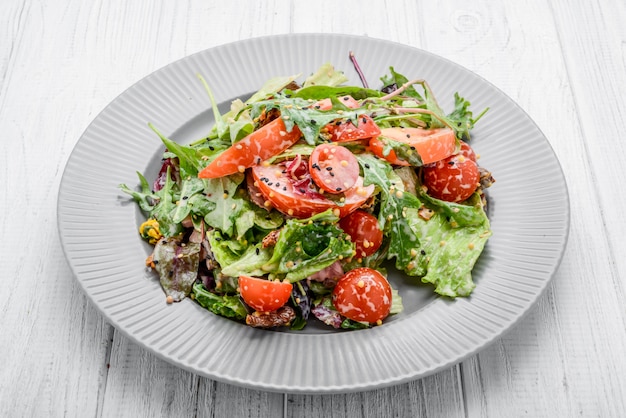 Salad with fresh vegetables with dried tomatoes, meat and mustard.