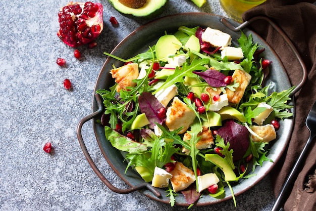 Salad with grilled chicken avocado brie cheese arugula and pomegranate Copy space