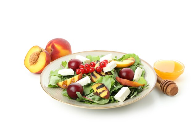 Salad with grilled peach isolated on white background