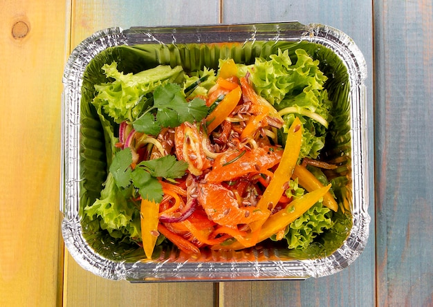 Salad with grilled vegetables and grapefruit in containers on a colored background Takeaway Diet and healthy food