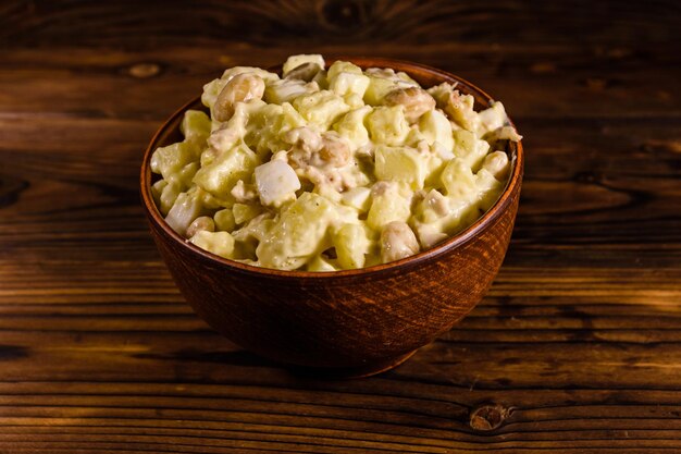 Salad with the haricot beans and meat dressed with mayonnaise in ceramic bowl