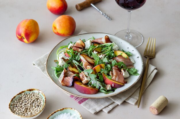 Salad with peaches, arugula, cheese and jamon. Healthy eating.