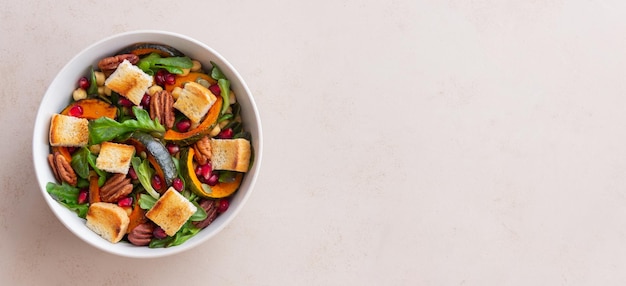 Salad with pumpkin, pomegranate, pecans and croutons. Healthy eating. Vegetarian food.