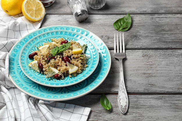 Salad with quinoa basil and beans served on grey wooden background