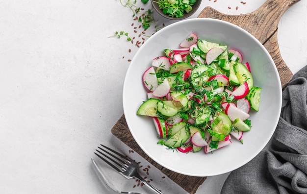 Salad with radish cucumber micro greens and flax seeds on a light background