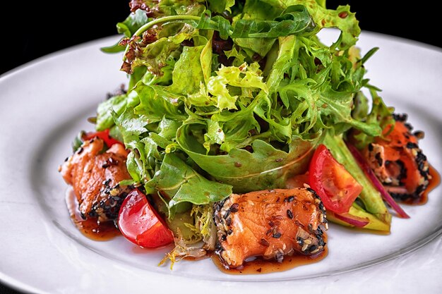 Salad with red fish herbs and tomatoes on a plate