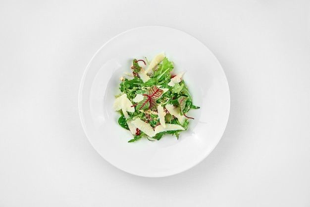 Salad with roast beef and parmesan on a white plate Closeup Selective focus