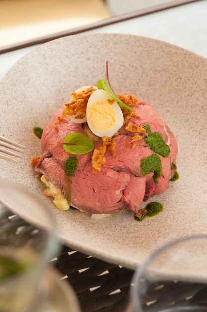 Salad with roast beef quail egg and green butter in the restaurant