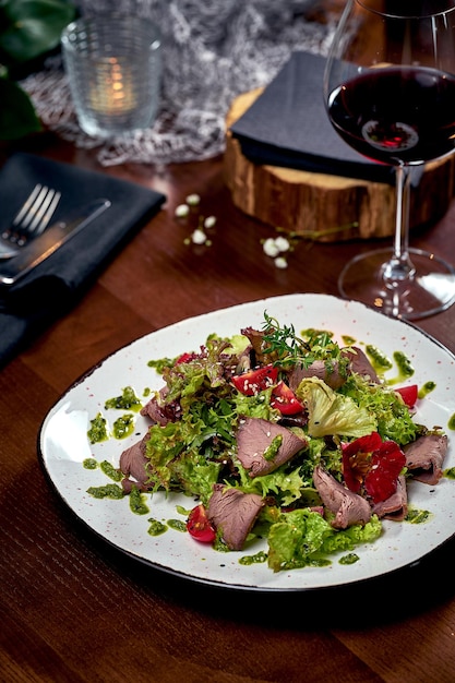 Salad with roast beef and sauce in a plate. Close-up, selective focus