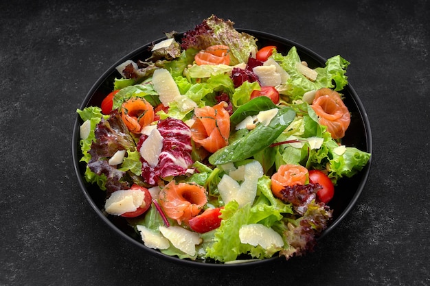 Salad with salmon parmesan cheese tomatoes and salad mix