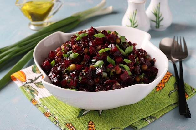 Photo salad with seaweed, beetroot and green onions in a white bowl on light blue background. close-up