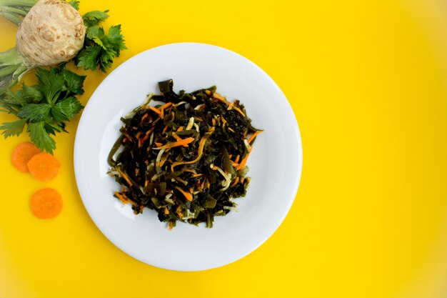 Salad with seaweed, celery and carrots in the white plate.Top view.Copy space.