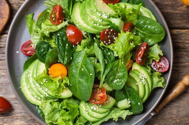 Salad with spinach avocado tomatoes in a plate Vegetarian salad