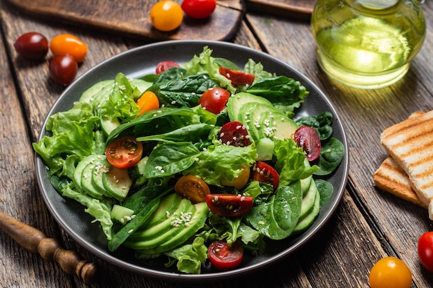 Salad with spinach avocado tomatoes in a plate Vegetarian salad