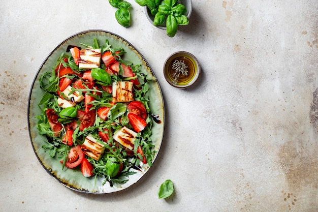 Salad with strawberries, tomatoes, arugula and halloumi cheese