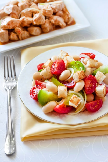 Salad with tomatoes boiled white kidney beans and croutons