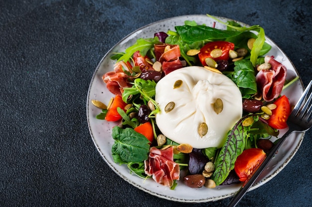 Salad with Tomatoes and Burrata cheese with basil and hamon Mozzarella cheese with salad