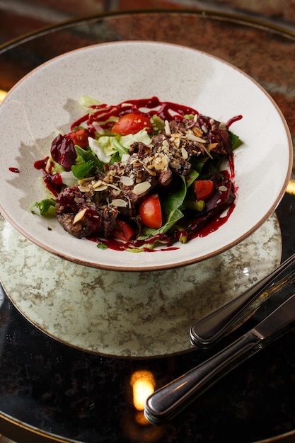 Salad with veal and tomatoes Beef steak with raw vegetables mix side view Grilled meat with garnish closeup Delicious main course on table