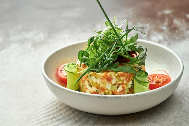 Salad with vegetables and salmon in a plate on a textured background. Close-up, selective focus