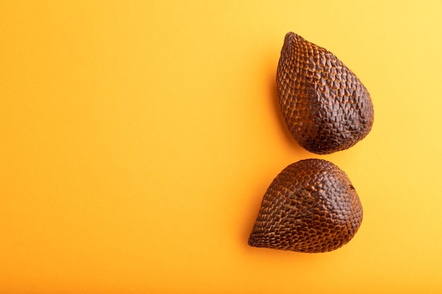 Salak or snake fruit on orange pastel background Top view copy space