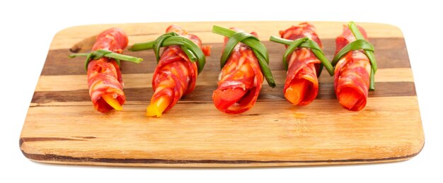 Salami rolls on wooden board isolated on white