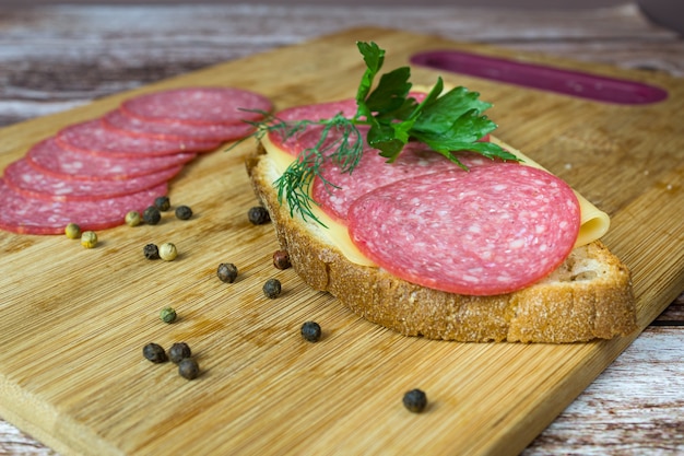 Salami sliced on bread on slicing board