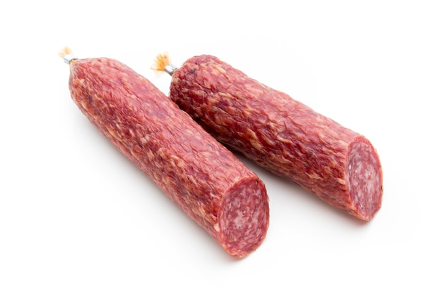 Salami smoked sausage, basil leaves and peppercorns isolated on white surface.