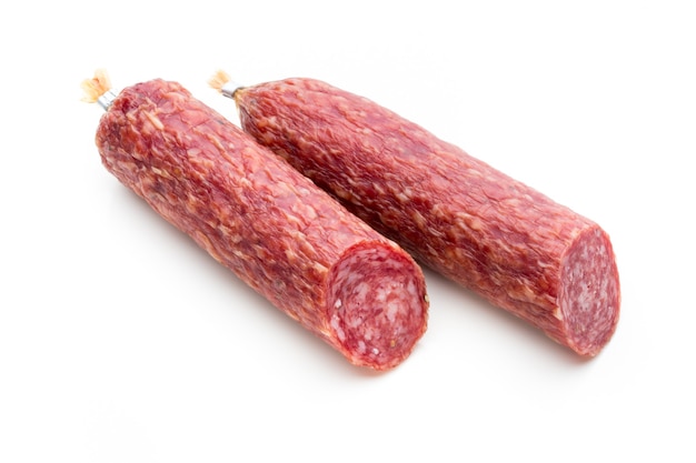 Salami smoked sausage, basil leaves and peppercorns isolated on white surface.