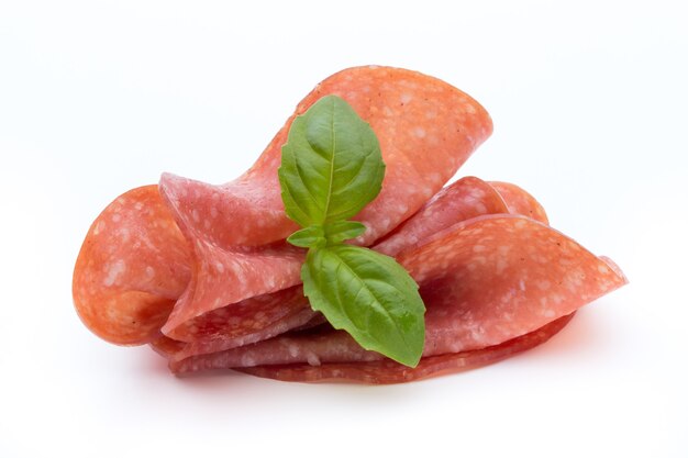 Salami smoked sausage slices isolated on white surface cutout.