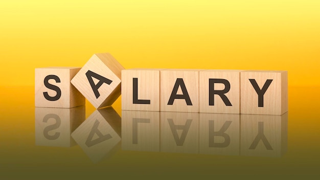 Salary text of on wooden cubes reflected from the bright yellow surface