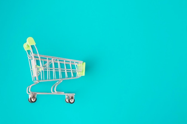 Sale and discounts concept supermarket trolley on a green background with copy space